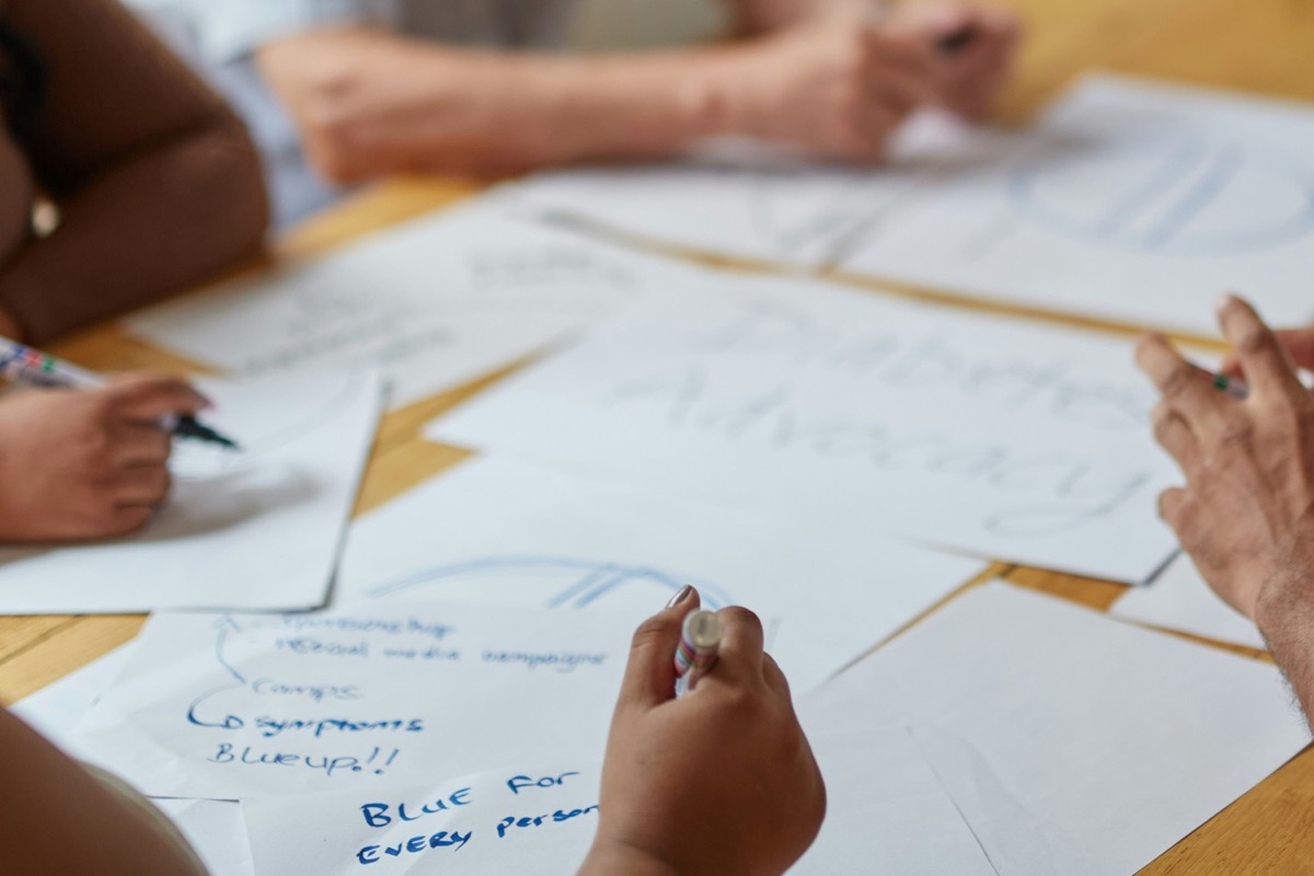 Hands working through notes and papers at a table
